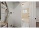 Bathroom adjacent to utility area, featuring tiled floor, bathtub, and natural light at 7460 Krameria Dr, Commerce City, CO 80022