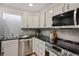 A close up of kitchen features stainless steel appliances, dark counter tops and white cabinets at 937 Clarkson St # 101, Denver, CO 80218