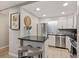 Bright kitchen features white cabinetry, stainless appliances, breakfast bar with seating, and stylish decor at 937 Clarkson St # 101, Denver, CO 80218