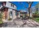 Charming backyard with stone patio, wrought iron table set, partial fence, and large shade tree at 1716 S Ogden St, Denver, CO 80210