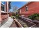 Backyard featuring raised garden beds and a brick house, with a wooden fence surrounding the perimeter at 1716 S Ogden St, Denver, CO 80210