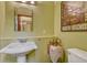 Bathroom featuring a pedestal sink, decorative mirror, and vintage decor on light green walls at 1716 S Ogden St, Denver, CO 80210