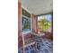 Cozy brick porch with seating area, patterned rug, and view of the surrounding neighborhood at 1716 S Ogden St, Denver, CO 80210