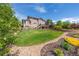 Lush backyard featuring a well-maintained lawn, mature trees, and decorative rock landscaping at 26741 E Arbor Dr, Aurora, CO 80016