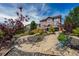 Beautiful backyard with a stone walkway, mature trees, and lush landscaping at 26741 E Arbor Dr, Aurora, CO 80016