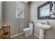 Stylish powder room with pedestal sink, decorative mirror, and window for natural light at 26741 E Arbor Dr, Aurora, CO 80016