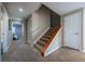 Carpeted staircase and hallway with neutral paint colors, white doors, and bright lighting at 26741 E Arbor Dr, Aurora, CO 80016
