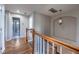 Upstairs hallway featuring hardwood floors, decorative lighting and staircase at 26741 E Arbor Dr, Aurora, CO 80016