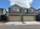 Two-story townhome exterior with attached two-car garages and neutral toned siding at 17991 E 103Rd Ave, Commerce City, CO 80022