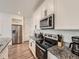 Updated kitchen featuring stainless steel appliances, granite countertops and white cabinetry at 17991 E 103Rd Ave, Commerce City, CO 80022