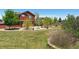 Spacious backyard with lush green lawn, a fire pit area, and mature landscaping at 4804 Eckert St, Castle Rock, CO 80104