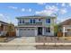 Beautiful two-story home with gray and white stone exterior, well-manicured front yard, and a two-car garage at 25273 E Warren Pl, Aurora, CO 80018