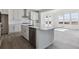 Bright, modern kitchen with white cabinets, stainless steel appliances, large island, and stylish finishes at 25273 E Warren Pl, Aurora, CO 80018
