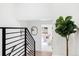 Upstairs hallway with modern railing and access to bedroom at 2355 Ivanhoe St, Denver, CO 80207