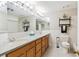 Bathroom featuring double sinks with oak cabinets, great lighting, and tiled floor at 5704 W Atlantic Pl, Lakewood, CO 80227