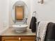 This traditional half bath features a pedestal sink, neutral paint, and a round mirror at 5704 W Atlantic Pl, Lakewood, CO 80227