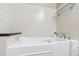 Accessible bathroom featuring safety walk-in tub and custom tile accents at 5704 W Atlantic Pl, Lakewood, CO 80227