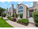 Inviting exterior view of townhome with large arched windows, lush landscaping, and well-maintained walkway at 5704 W Atlantic Pl, Lakewood, CO 80227