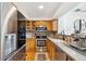 Well-equipped kitchen with stainless steel refrigerator, wood cabinets, stainless appliances, and modern finishes at 5704 W Atlantic Pl, Lakewood, CO 80227
