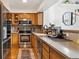Efficient kitchen featuring stainless steel appliances, wooden cabinetry, and modern countertops at 5704 W Atlantic Pl, Lakewood, CO 80227