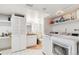 Bright laundry room adjacent to half bath, featuring white washer/dryer and ample storage at 5704 W Atlantic Pl, Lakewood, CO 80227