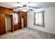 Bedroom has wall closet units, large window, ceiling fan with light, and neutral carpet at 254 Donna St, Fort Lupton, CO 80621