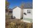 Outdoor view of a white shed with a red gate, set next to the main house at 254 Donna St, Fort Lupton, CO 80621