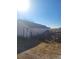 Image displays a well-kept exterior of a building with red metal fencing and a rustic door at 254 Donna St, Fort Lupton, CO 80621