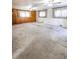 Spacious living room with carpet, wood-paneled walls, and lots of natural light through draped windows at 254 Donna St, Fort Lupton, CO 80621