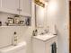 Bathroom featuring a white vanity, a sink, a mirror, and a cabinet, complemented by natural light at 6837 S Brook Forest Rd, Evergreen, CO 80439