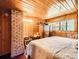 Wood-paneled bedroom with a large window offering natural light and a view, complemented by wooden floors at 6837 S Brook Forest Rd, Evergreen, CO 80439