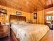 Spacious wood-paneled bedroom featuring a comfortable bed and classic design for a warm and inviting feel at 6837 S Brook Forest Rd, Evergreen, CO 80439