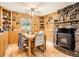 Cozy dining room with wood-paneled walls and a fireplace, creating a warm and inviting atmosphere at 6837 S Brook Forest Rd, Evergreen, CO 80439