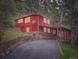 Charming red home with stone foundation and covered parking in a serene wooded setting at 6837 S Brook Forest Rd, Evergreen, CO 80439