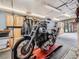 Well-lit garage with a motorcycle and storage cabinets at 6837 S Brook Forest Rd, Evergreen, CO 80439