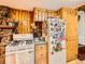 Cozy kitchen with a white stove and a refrigerator adorned with magnets next to a stone fireplace at 6837 S Brook Forest Rd, Evergreen, CO 80439