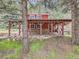 Charming red home with covered outdoor living space perfect for relaxation and entertaining at 6837 S Brook Forest Rd, Evergreen, CO 80439
