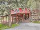Charming red home with covered outdoor living space perfect for relaxation and entertaining at 6837 S Brook Forest Rd, Evergreen, CO 80439