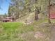 Lush backyard with mature trees and a red house at 6837 S Brook Forest Rd, Evergreen, CO 80439