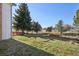 Expansive back yard featuring mature trees, a red deck, and a garden plot at 7761 Everett Way, Arvada, CO 80005