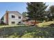 The backyard has mature trees and a lawn and adjoins a wooden deck on the back of the home at 7761 Everett Way, Arvada, CO 80005