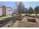 Large backyard featuring raised garden beds, a lawn, and mature trees, offering ample space for outdoor activities at 7761 Everett Way, Arvada, CO 80005