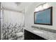 Bathroom featuring granite countertop, dark cabinets, and a shower and tub at 7761 Everett Way, Arvada, CO 80005