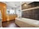 Elegant bathroom featuring a luxurious soaking tub, vanity with storage, and modern tile work complemented by recessed lighting at 7761 Everett Way, Arvada, CO 80005