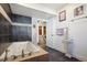 A modern bathroom features a deep soaking tub, decorative tile and shelving, accented by neutral walls and marble flooring at 7761 Everett Way, Arvada, CO 80005