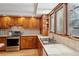 Cozy kitchen area with stainless steel appliances, wooden cabinetry, and a bright window over the sink with tile backsplash at 7761 Everett Way, Arvada, CO 80005