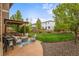 Expansive backyard with a covered patio, lush green grass, and well-maintained landscaping at 9570 Kendrick Way, Arvada, CO 80007
