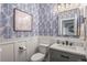 Charming half bathroom with blue patterned wallpaper, modern fixtures, and white wainscoting at 9570 Kendrick Way, Arvada, CO 80007