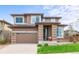 Beautiful two-story home featuring a brick facade, a two-car garage, and well-manicured lawn at 9570 Kendrick Way, Arvada, CO 80007
