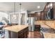 Bright, open kitchen with stainless appliances, granite countertops, dark wood cabinets, and a large island at 9570 Kendrick Way, Arvada, CO 80007